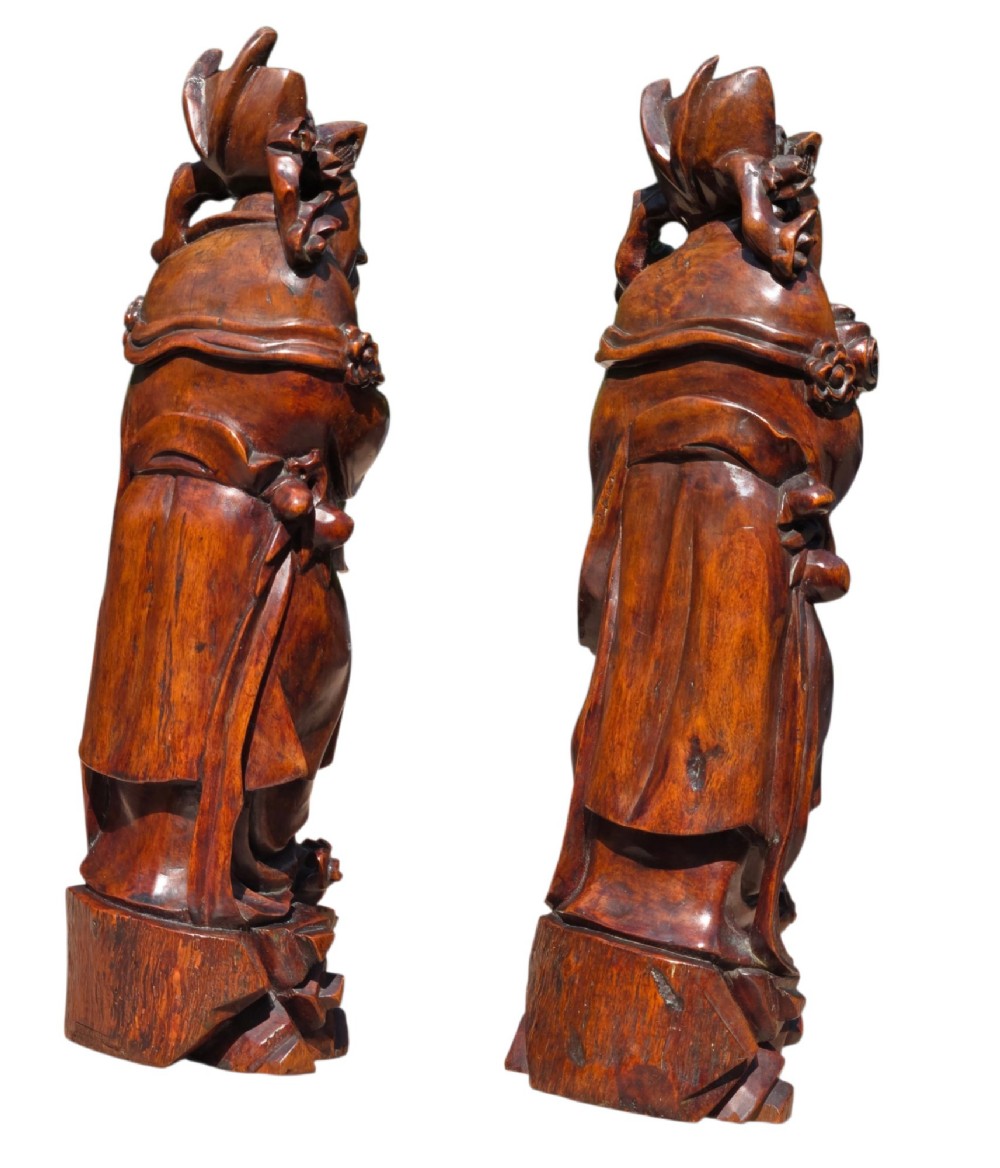 A pair of Chinese hardwood sculptures depicting Daoist immortals in flowing robes with carved geometric bases. View VIII