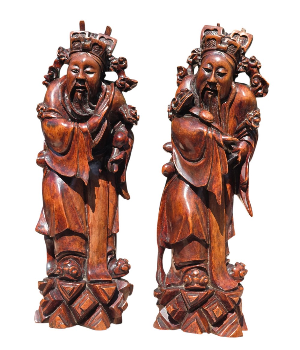 A pair of Chinese hardwood sculptures depicting Daoist immortals in flowing robes with carved geometric bases. View XI