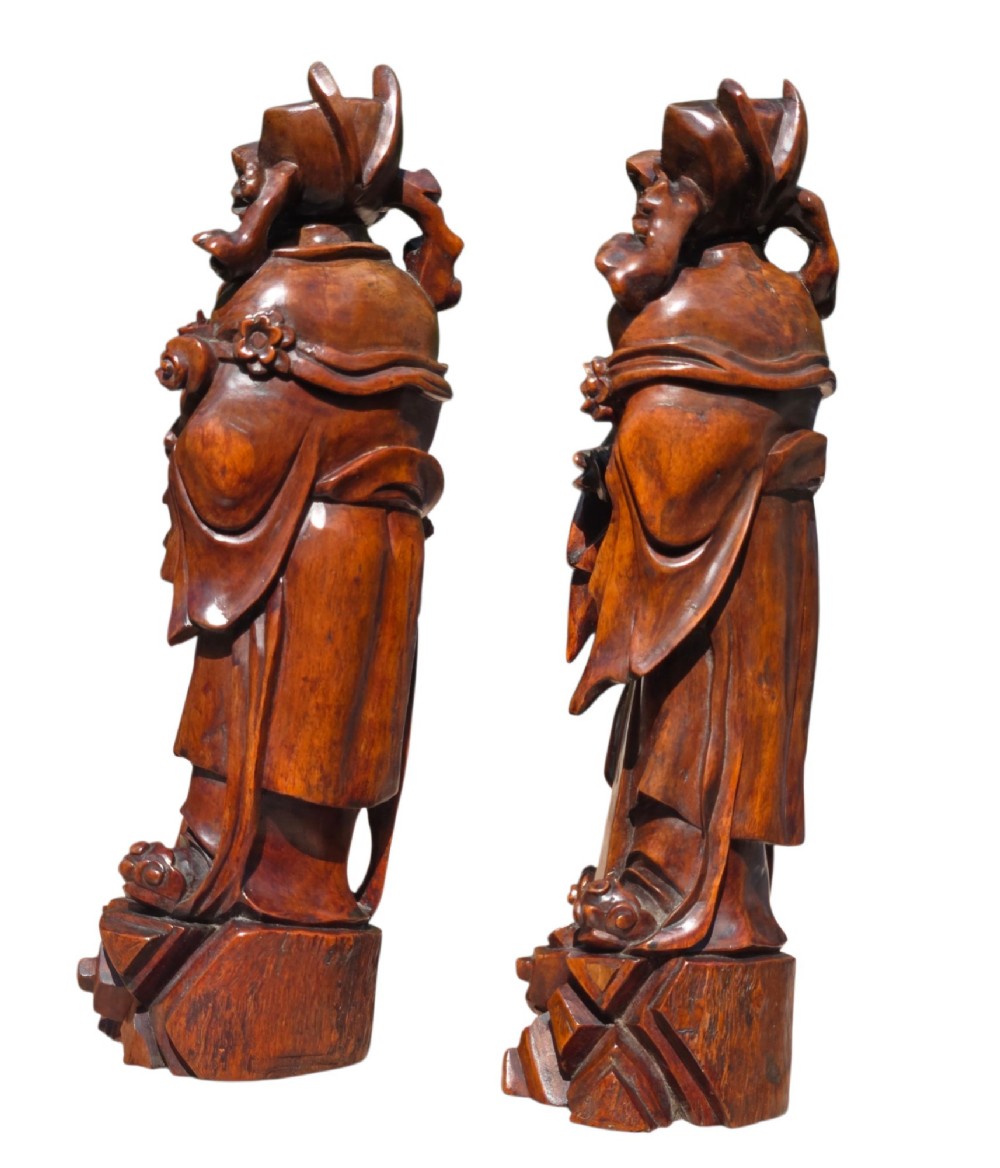 A pair of Chinese hardwood sculptures depicting Daoist immortals in flowing robes with carved geometric bases. View XII