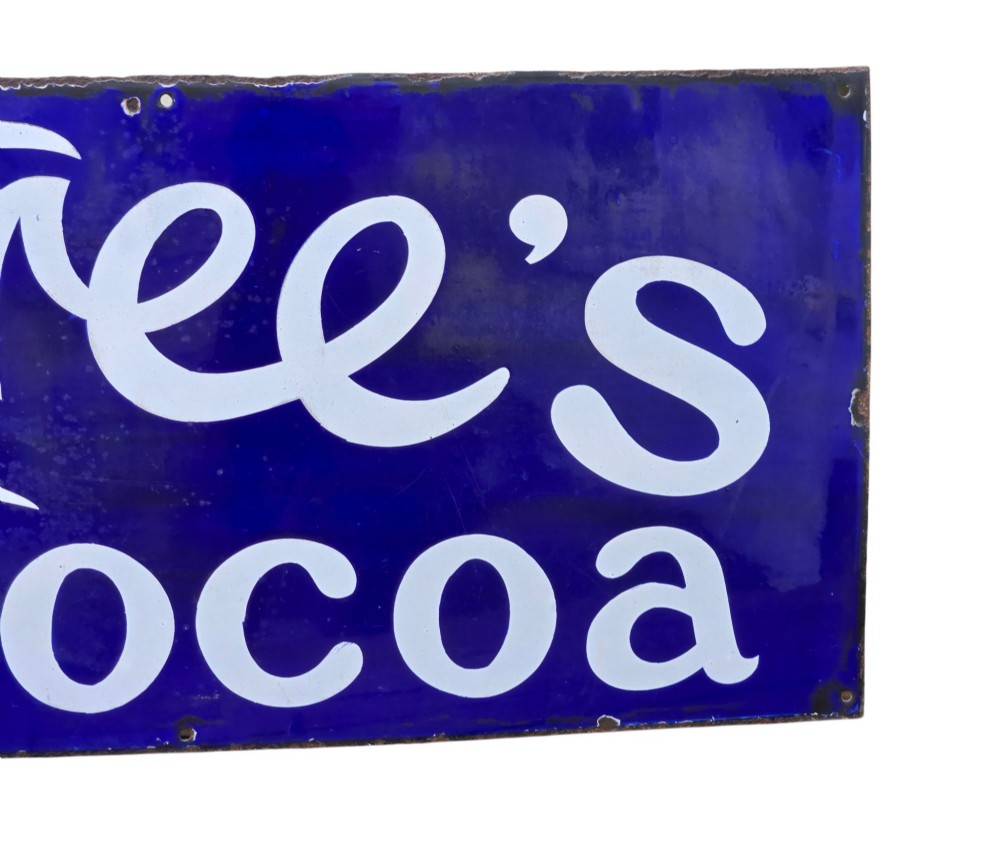 A rectangular cobalt blue vitreous enamel advertising sign featuring white script reading Rowntrees Cocoa and yellow lettering reading Elect Cocoa, topped with a royal warrant crest. View VII