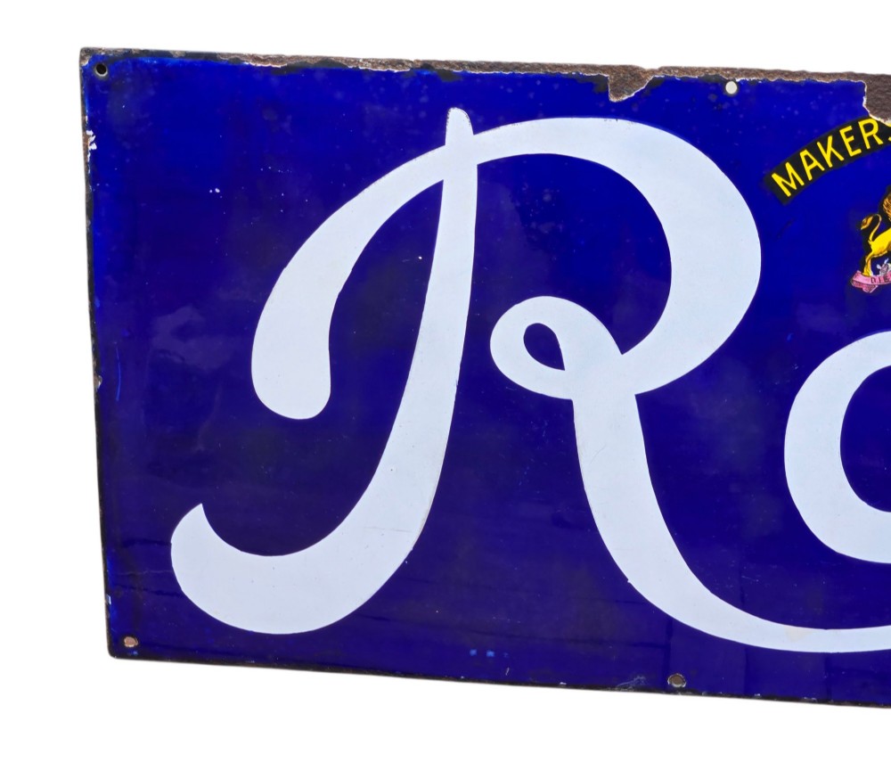 A rectangular cobalt blue vitreous enamel advertising sign featuring white script reading Rowntrees Cocoa and yellow lettering reading Elect Cocoa, topped with a royal warrant crest. View IX