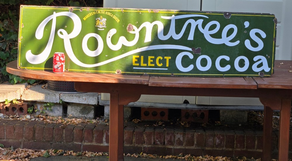 A large rectangular bottle green enamel sign featuring white and yellow typography for Rowntrees Elect Cocoa with a royal crest. View XIV