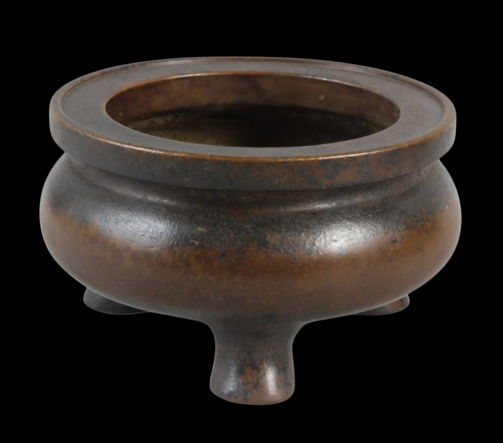 A heavy 17th-century Chinese archaistic bronze tripod censer featuring a compressed globular body, wide flat rim, dark brown patina, and three sturdy feet. View II