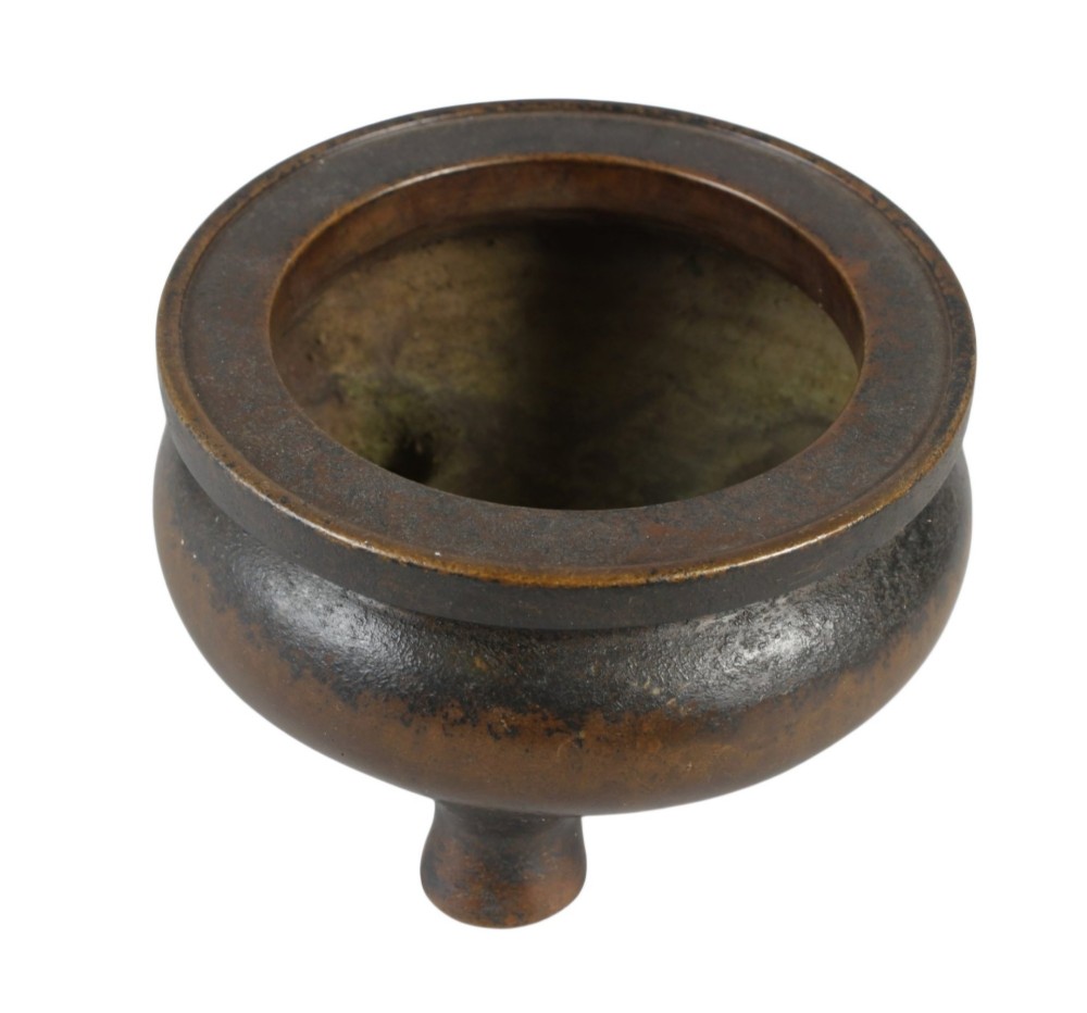 A heavy 17th-century Chinese archaistic bronze tripod censer featuring a compressed globular body, wide flat rim, dark brown patina, and three sturdy feet. View VI