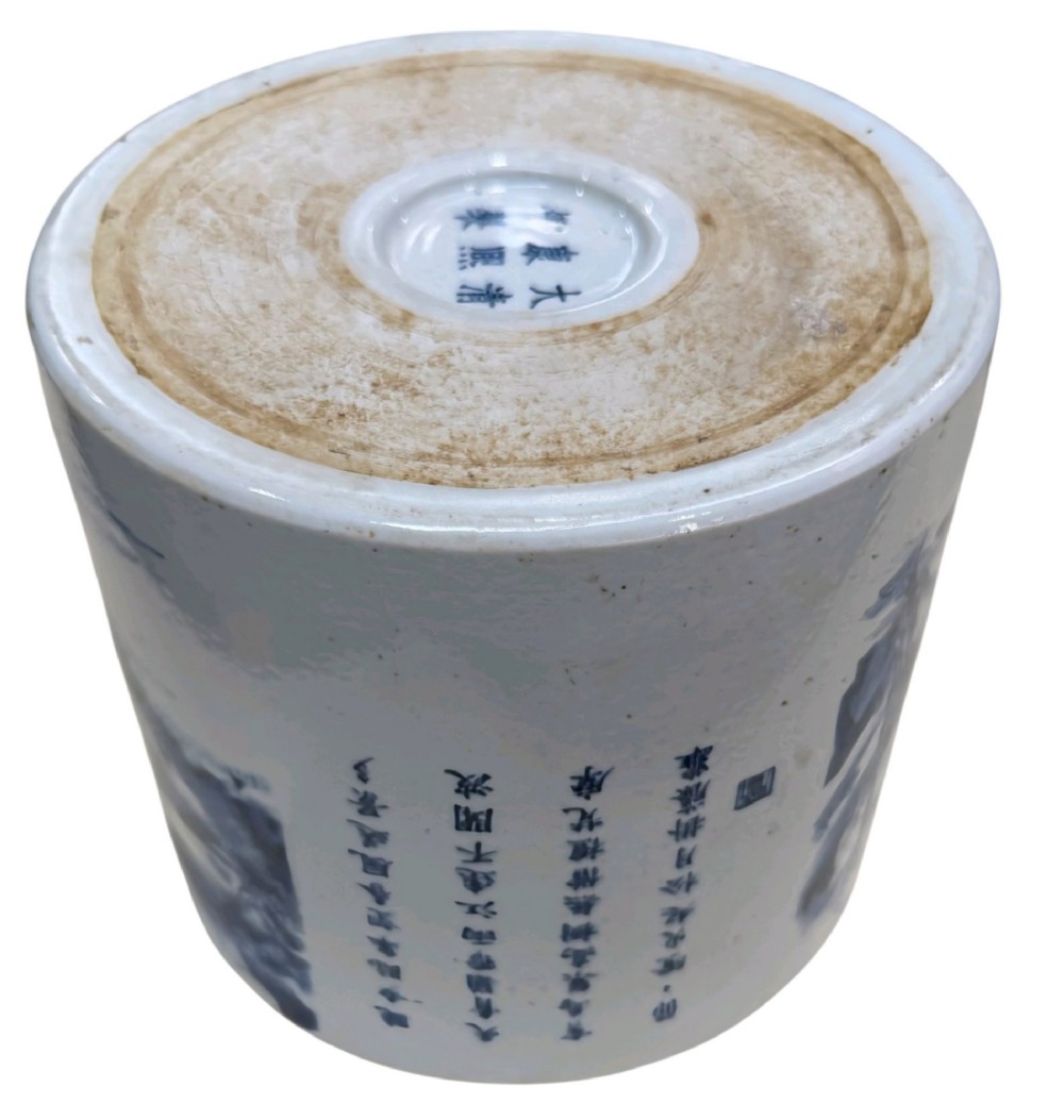 A cylindrical Chinese blue and white porcelain brush pot decorated with a painted mountain landscape and calligraphic text. View IX