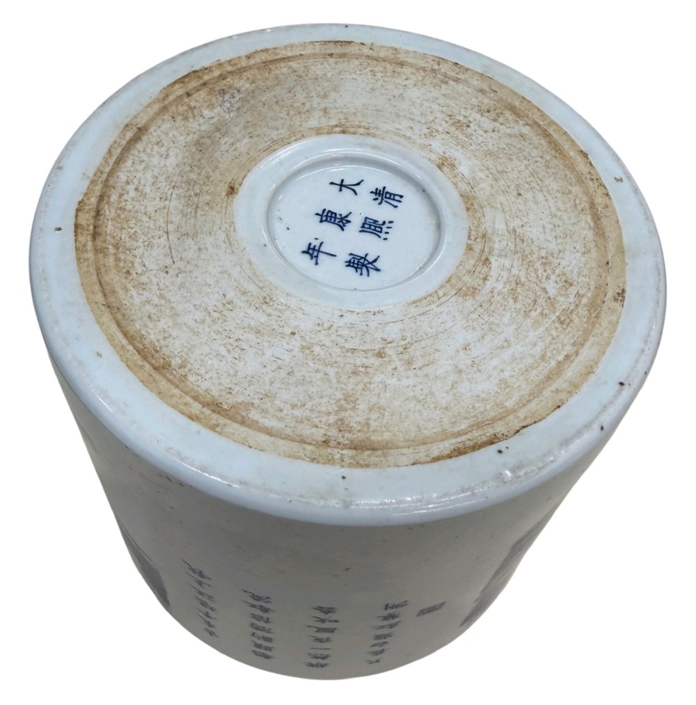A cylindrical Chinese blue and white porcelain brush pot decorated with a painted mountain landscape and calligraphic text. View XIV