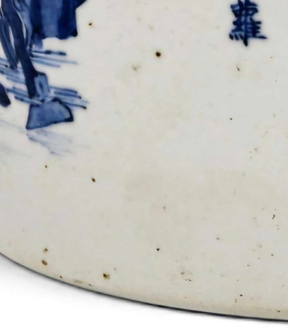 A cylindrical Chinese blue and white porcelain brush pot decorated with a painted mountain landscape and calligraphic text. View XV
