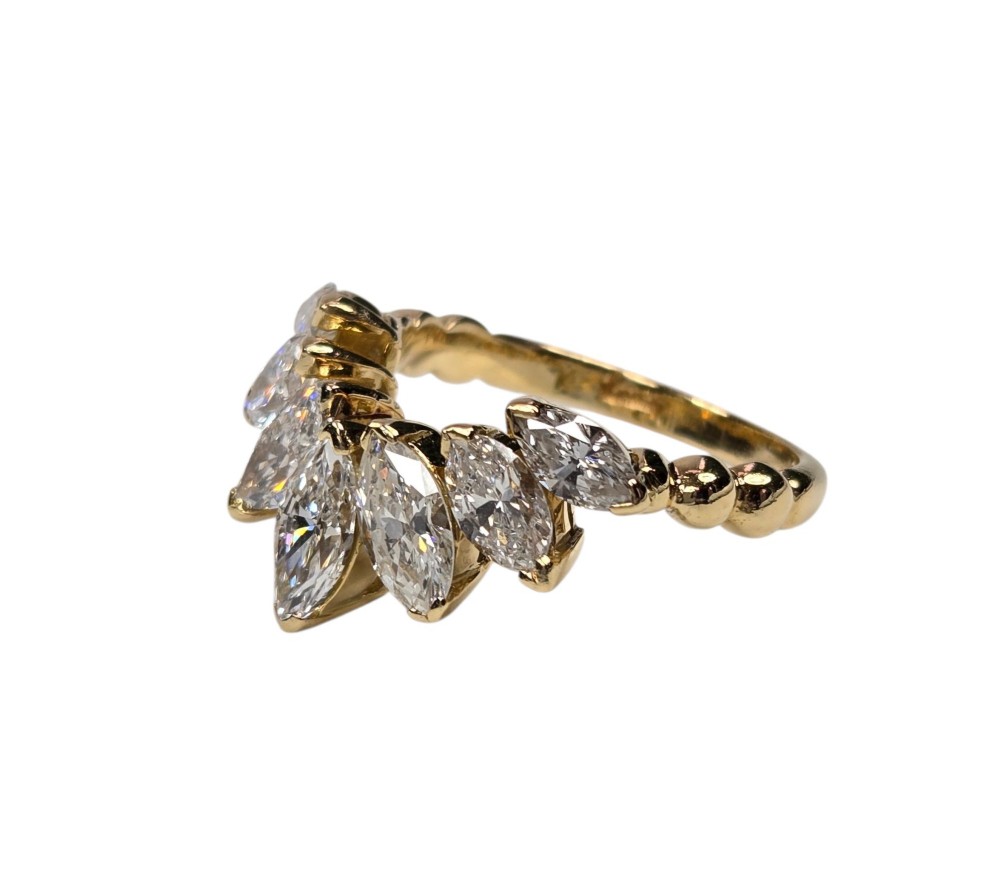 An 18ct yellow gold dress ring by Kutchinsky featuring a graduated row of marquise-cut diamonds mounted on a textured beaded shank. View XII