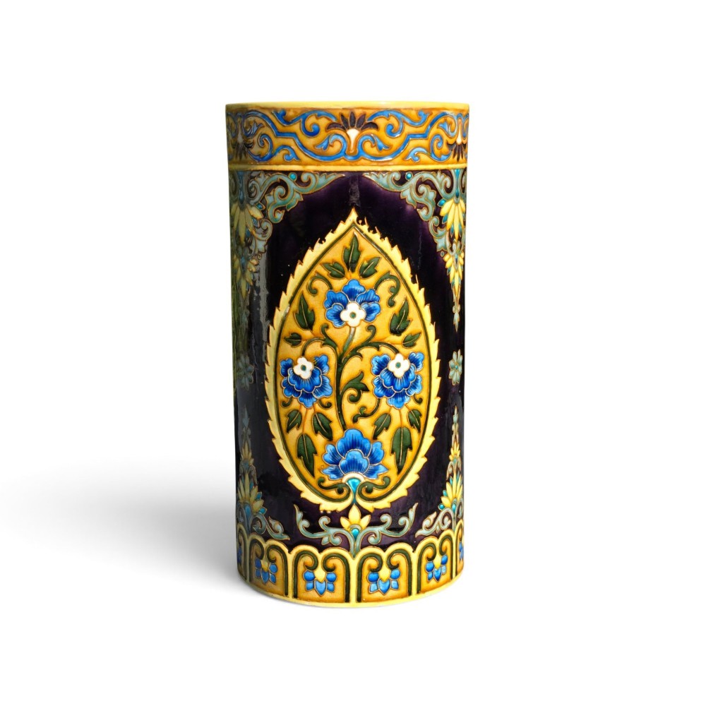 A tall cylindrical ceramic umbrella stand decorated with colourful Iznik-style floral medallions, turquoise scrolling foliage, and a deep purple glazed background. View II