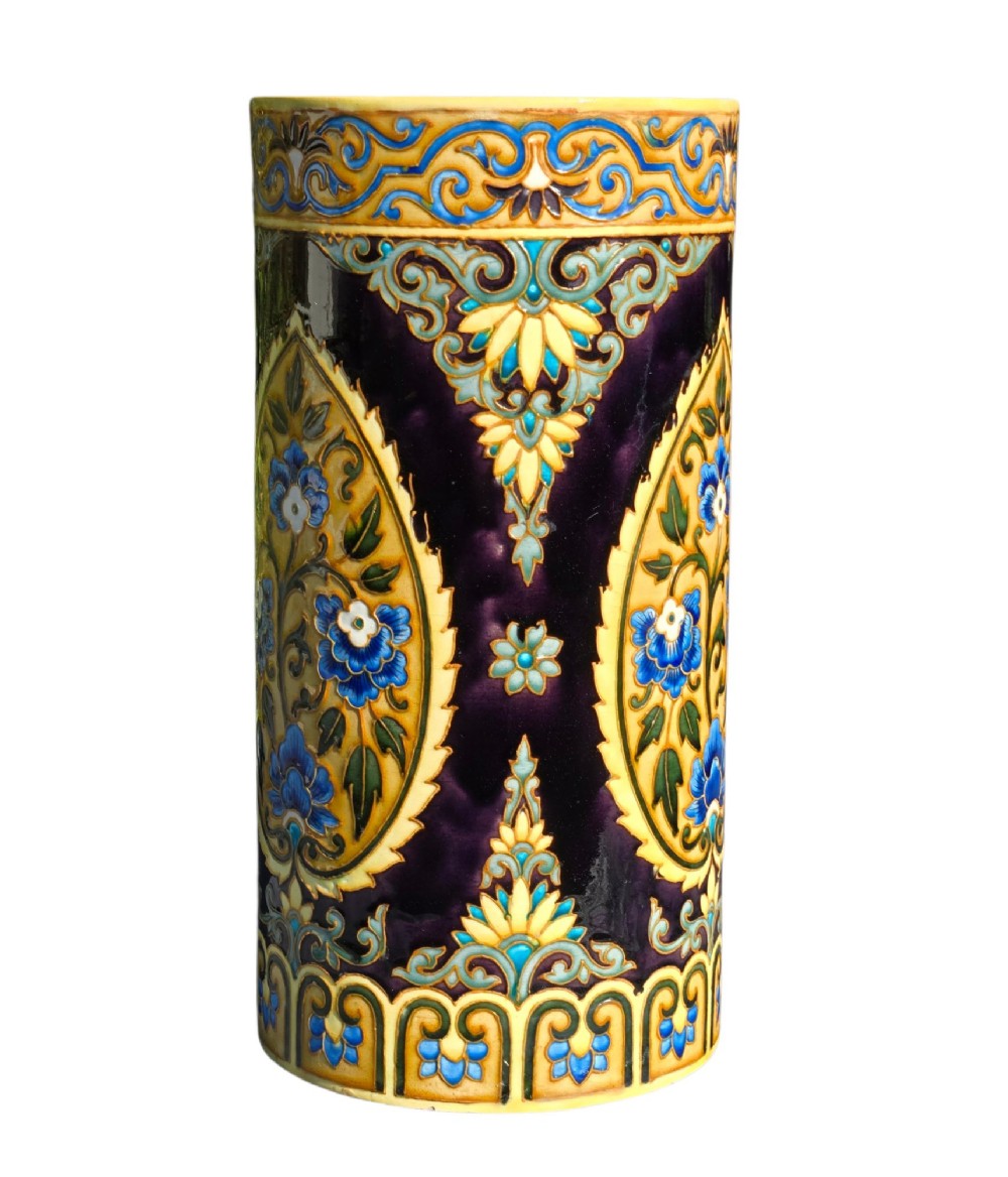 A tall cylindrical ceramic umbrella stand decorated with colourful Iznik-style floral medallions, turquoise scrolling foliage, and a deep purple glazed background. View VII