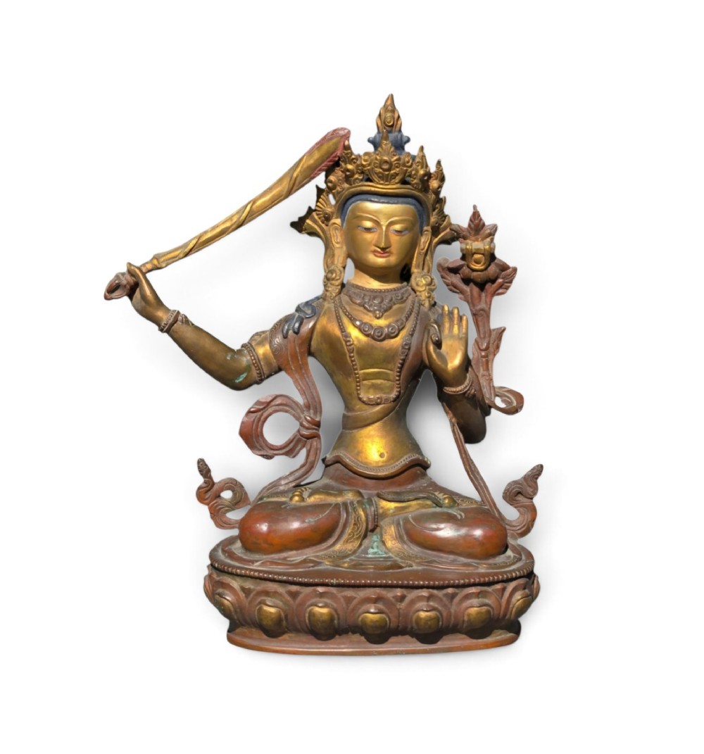 An antique Sino-Tibetan gilt-bronze figure of Bodhisattva Manjushri seated cross-legged on a double-lotus base, brandishing a flaming sword in his right hand. View II