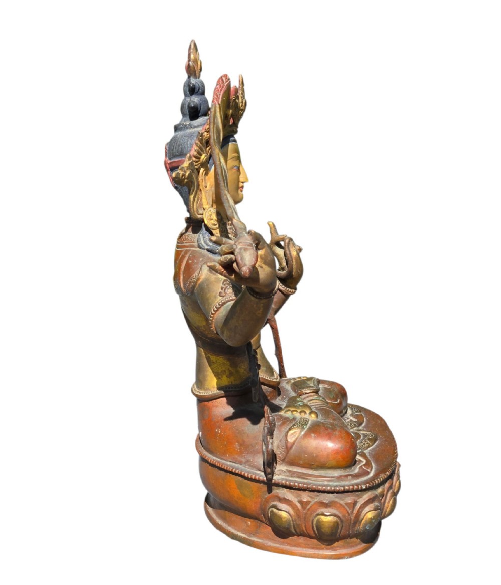 An antique Sino-Tibetan gilt-bronze figure of Bodhisattva Manjushri seated cross-legged on a double-lotus base, brandishing a flaming sword in his right hand. View IX