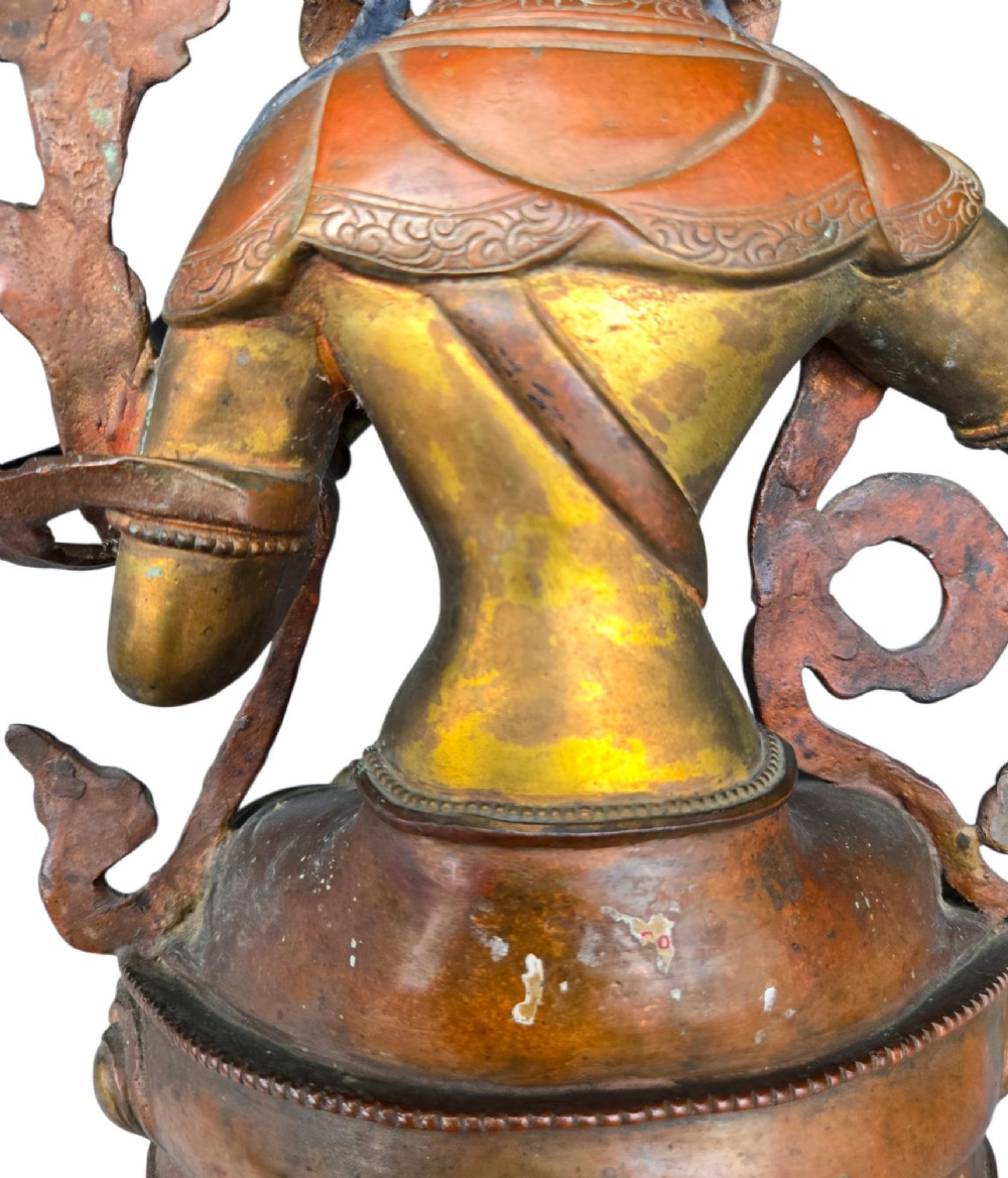 An antique Sino-Tibetan gilt-bronze figure of Bodhisattva Manjushri seated cross-legged on a double-lotus base, brandishing a flaming sword in his right hand. View XV