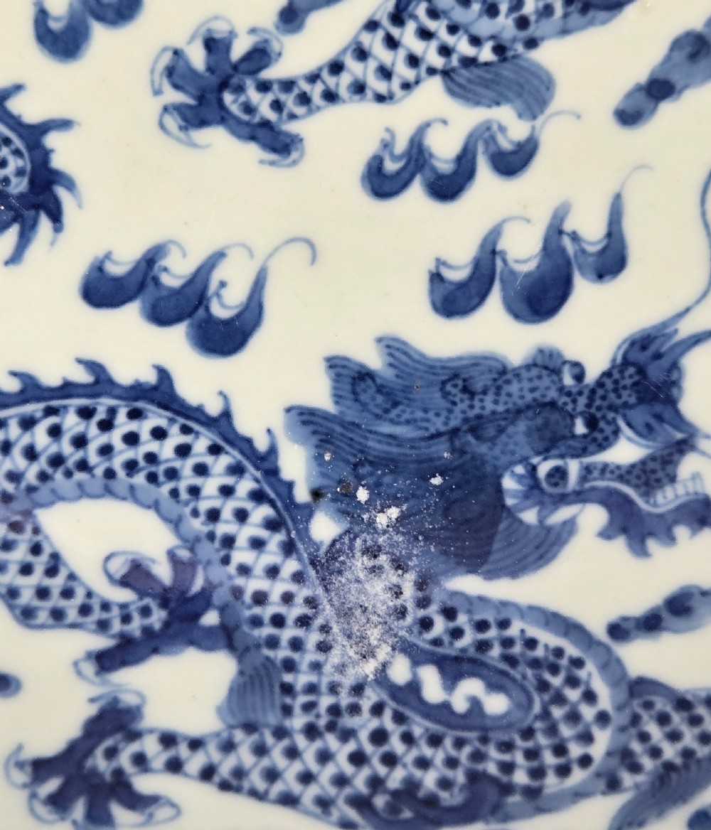 A circular Chinese blue and white porcelain charger featuring five-clawed dragons depicted among stylized clouds and flaming pearls. View VI