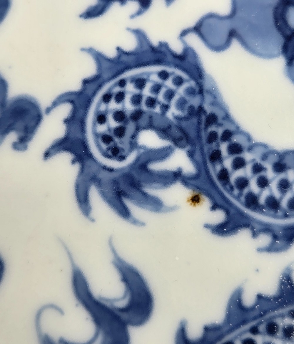 A circular Chinese blue and white porcelain charger featuring five-clawed dragons depicted among stylized clouds and flaming pearls. View XV