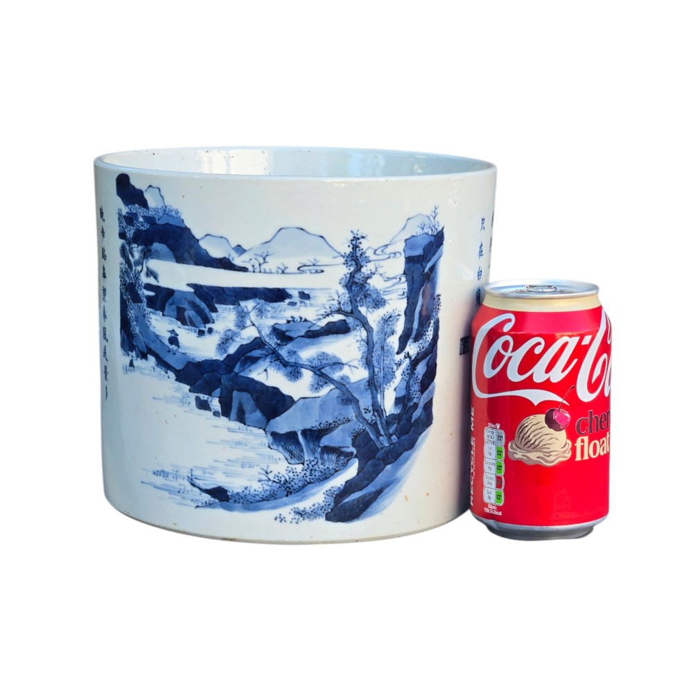 A cylindrical Chinese blue and white porcelain brush pot decorated with a painted mountain landscape and calligraphic text. View XV