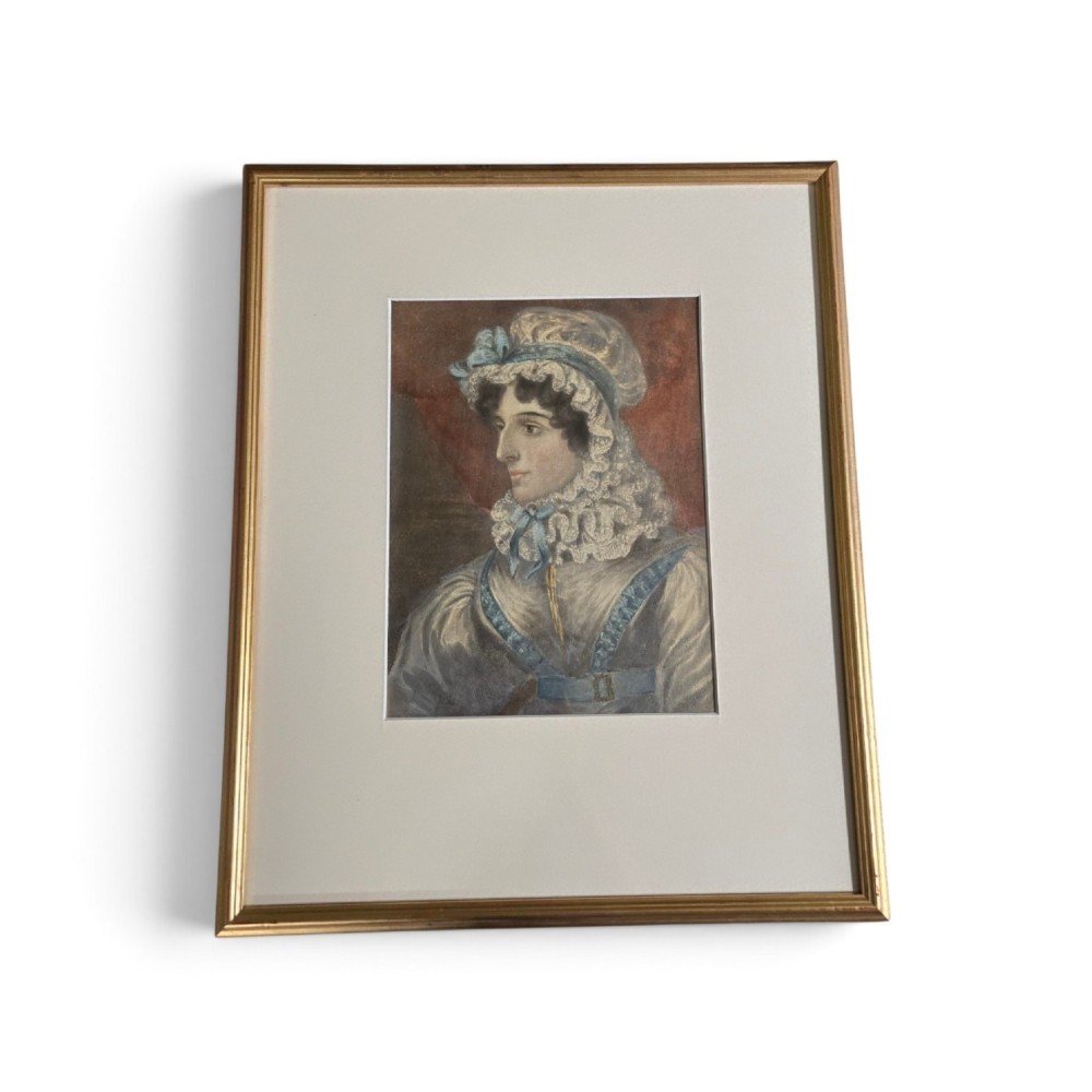 A framed 19th-century watercolour portrait depicting a lady wearing a lace bonnet trimmed with blue ribbons. View II
