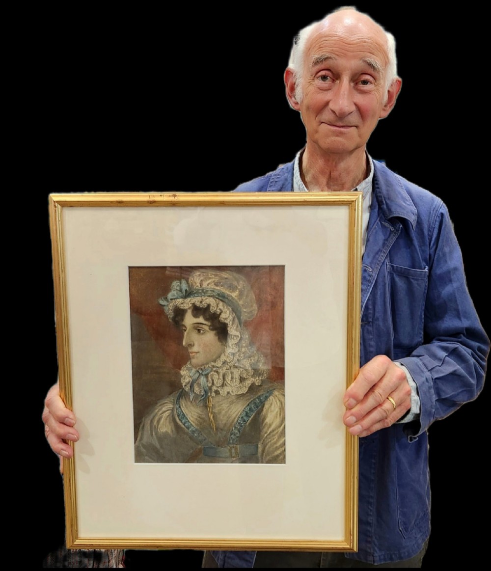 A framed 19th-century watercolour portrait depicting a lady wearing a lace bonnet trimmed with blue ribbons. View V