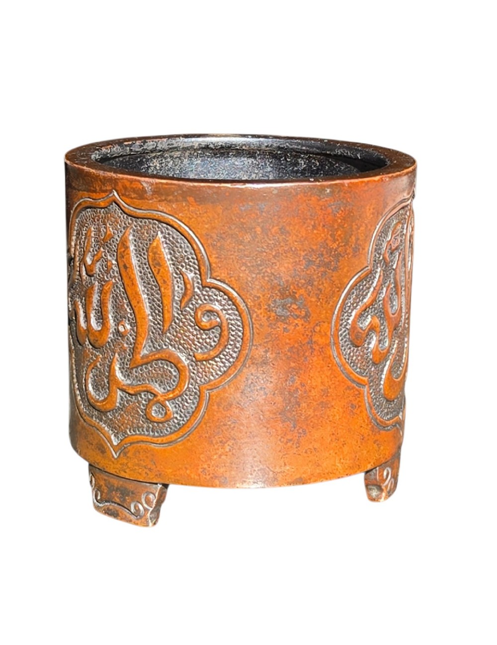 A cylindrical warm brown bronze tripod censer featuring a raised lobed cartouche with Arabic calligraphy set against a textured ground. View VII