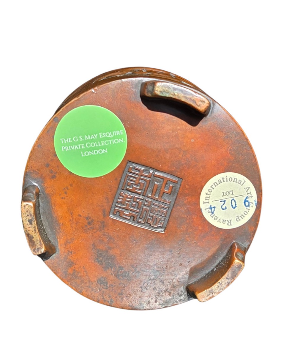 A cylindrical warm brown bronze tripod censer featuring a raised lobed cartouche with Arabic calligraphy set against a textured ground. View XIII