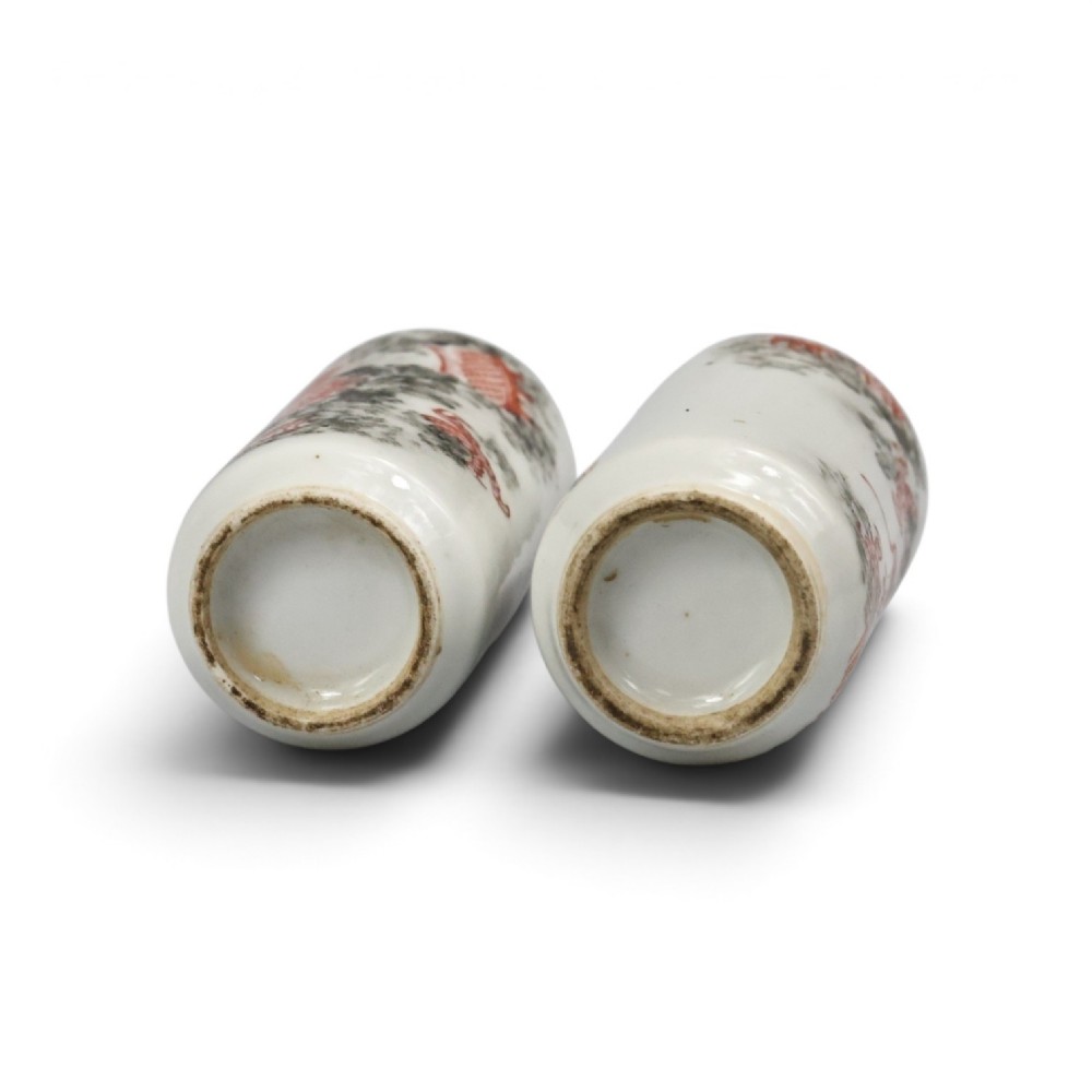 A matched pair of cylindrical off-white Chinese porcelain snuff bottles decorated with detailed iron-red dragons amongst grey clouds. View V