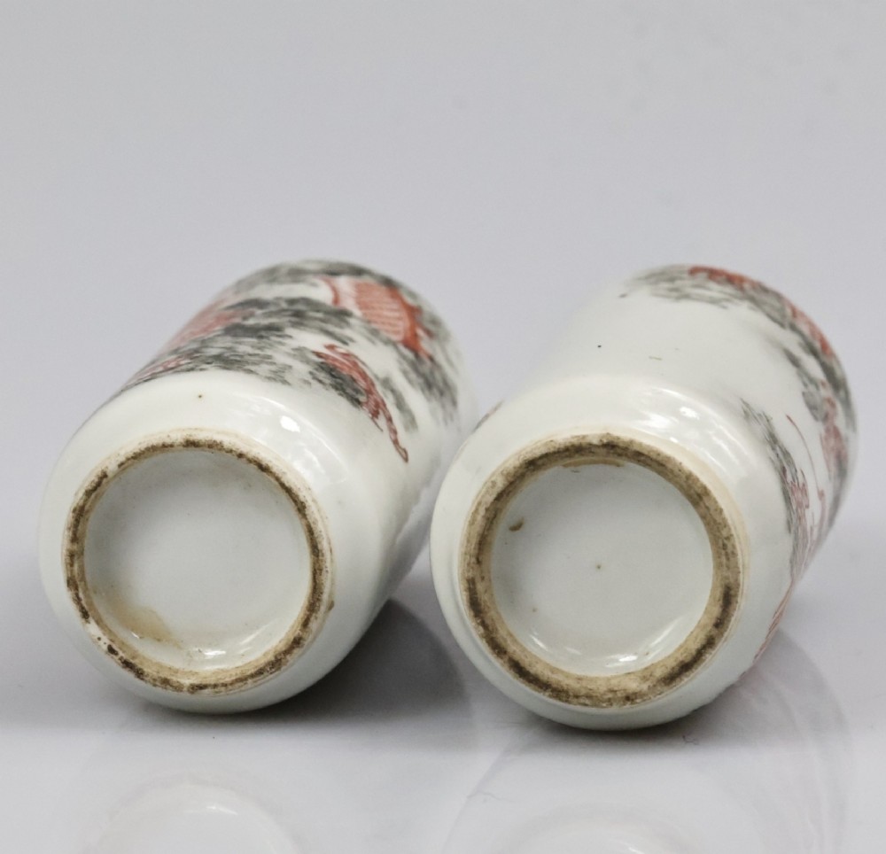 A matched pair of cylindrical off-white Chinese porcelain snuff bottles decorated with detailed iron-red dragons amongst grey clouds. View XII