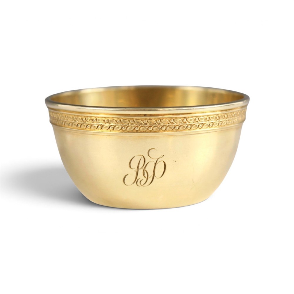 A circular gold silver-gilt presentation bowl featuring an engraved monogram and a carved leaf border near the upper rim.