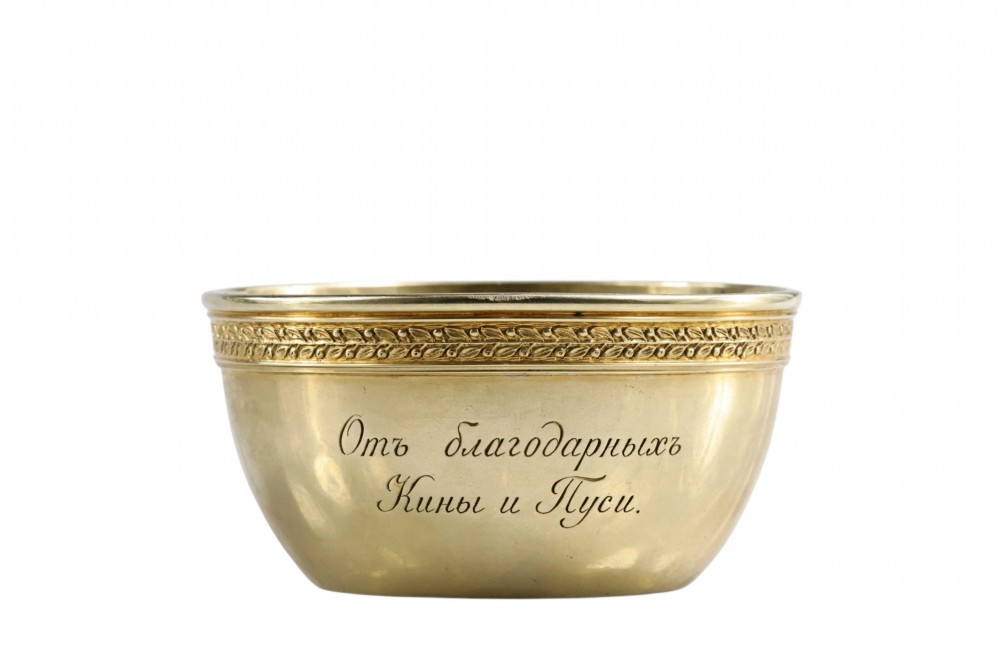 A circular gold silver-gilt presentation bowl featuring an engraved monogram and a carved leaf border near the upper rim. View X
