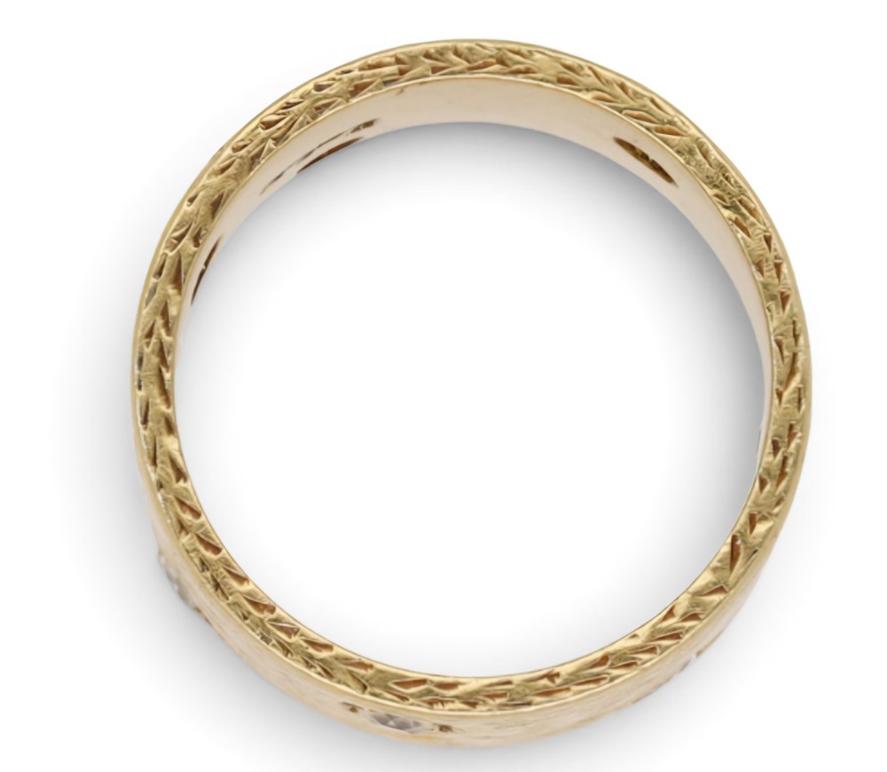 A wide 18ct yellow gold band ring featuring a textured bark-like surface set with brilliant-cut diamonds and stamped with London hallmarks inside. View IV