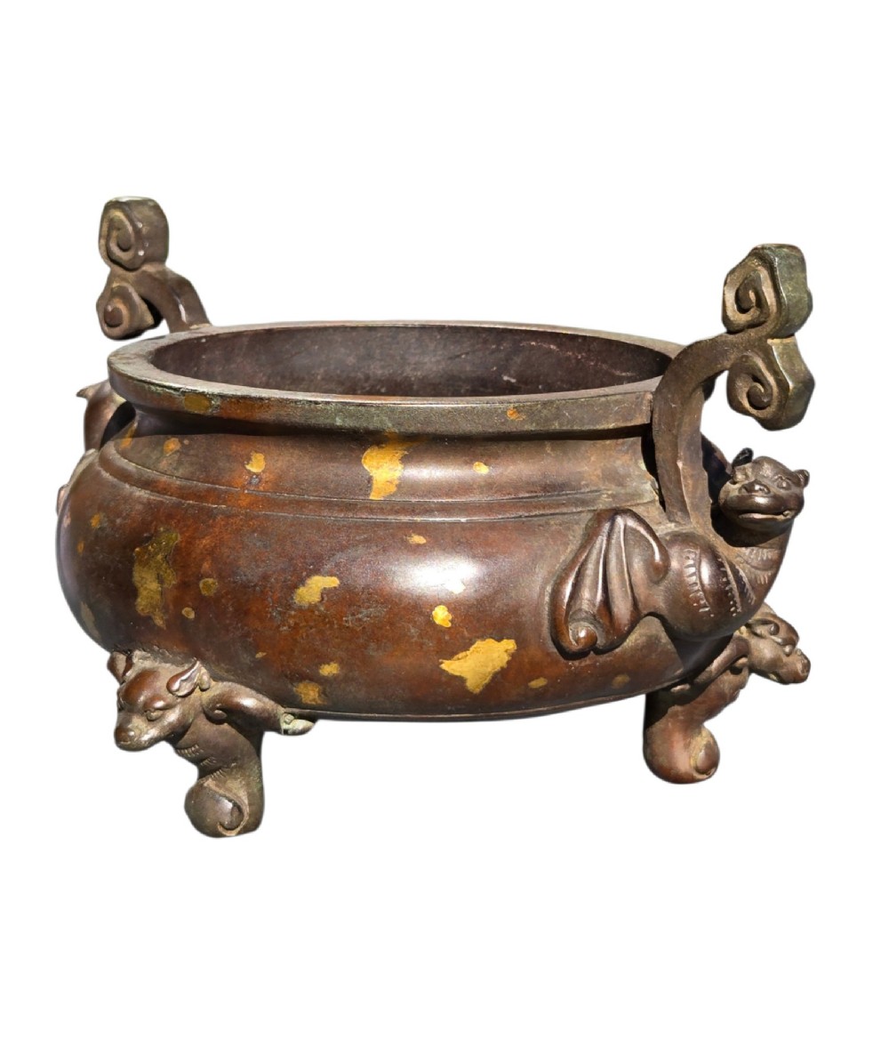 An 18th-century Chinese gilt-splashed bronze tripod censer featuring scroll handles, animal-mask legs, a dark hardwood cover topped with a carved jade finial, and a fitted bronze stand. View VII