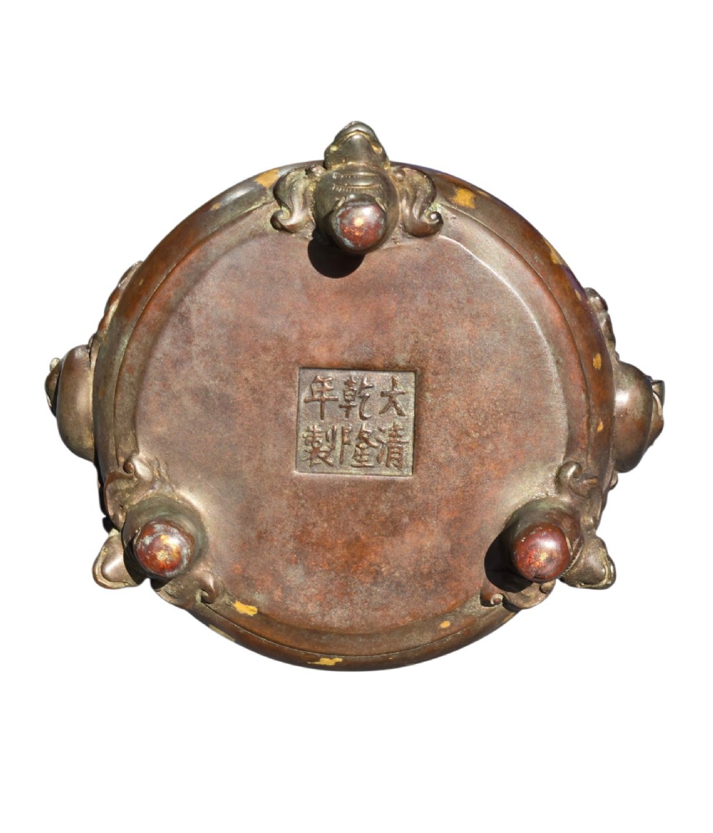An 18th-century Chinese gilt-splashed bronze tripod censer featuring scroll handles, animal-mask legs, a dark hardwood cover topped with a carved jade finial, and a fitted bronze stand. View XIII