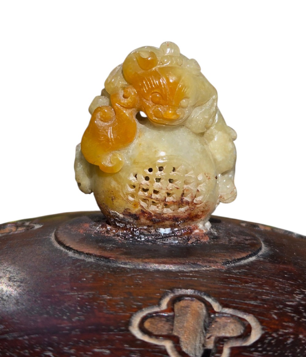 An 18th-century Chinese gilt-splashed bronze tripod censer featuring scroll handles, animal-mask legs, a dark hardwood cover topped with a carved jade finial, and a fitted bronze stand. View XV