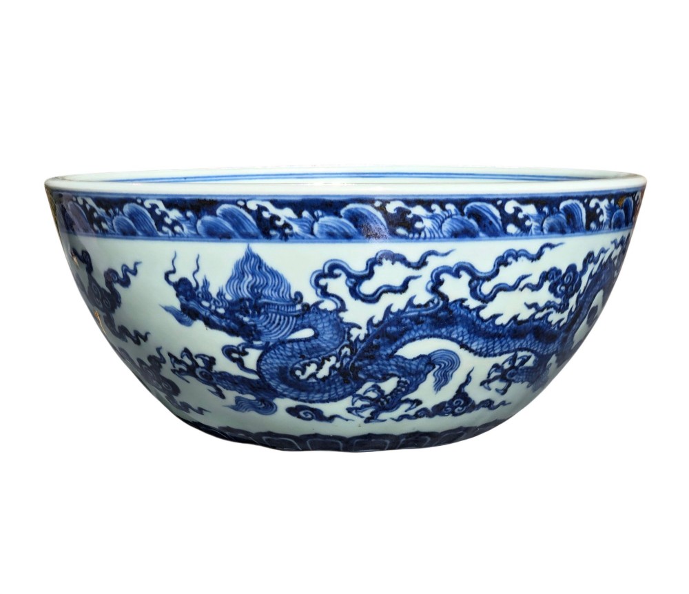 A large circular porcelain bowl featuring hand-painted cobalt blue dragons and wave motifs against a white ground. View VII