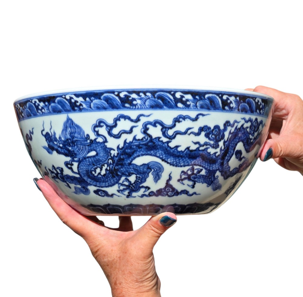 A large circular porcelain bowl featuring hand-painted cobalt blue dragons and wave motifs against a white ground. View IX