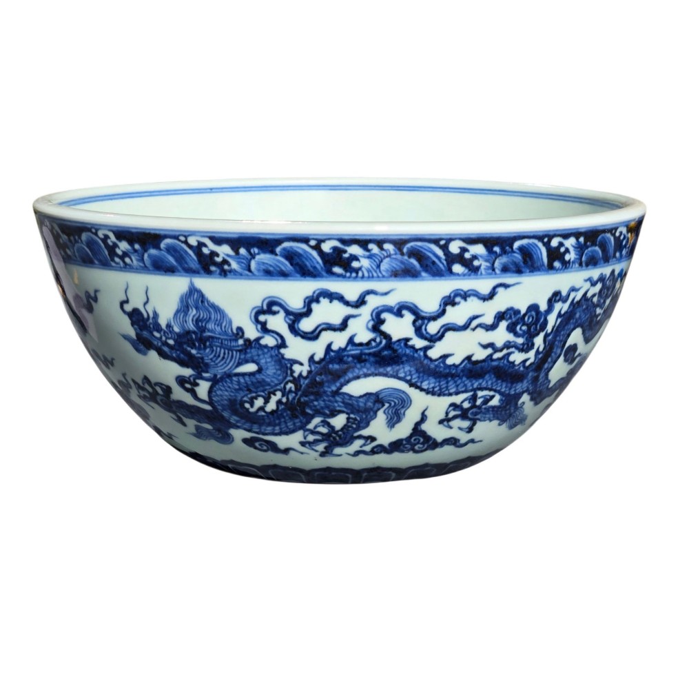 A large circular porcelain bowl featuring hand-painted cobalt blue dragons and wave motifs against a white ground. View XI