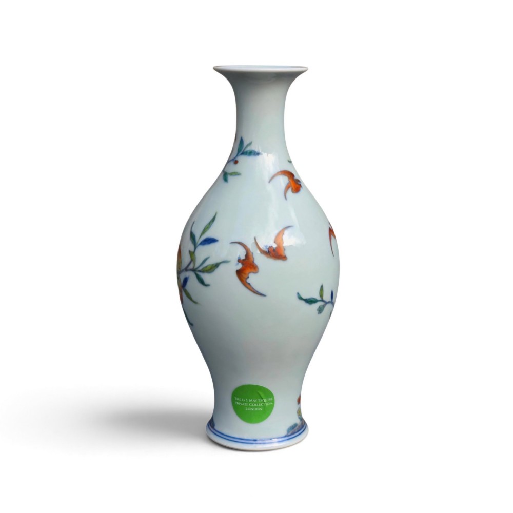 A Chinese porcelain garlic-head vase decorated with hand-painted peaches, orange bats, green leaves, and blue rockwork on a white background. View V