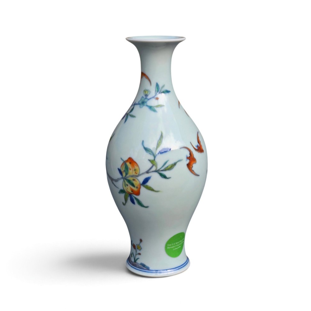 A Chinese porcelain garlic-head vase decorated with hand-painted peaches, orange bats, green leaves, and blue rockwork on a white background. View VI