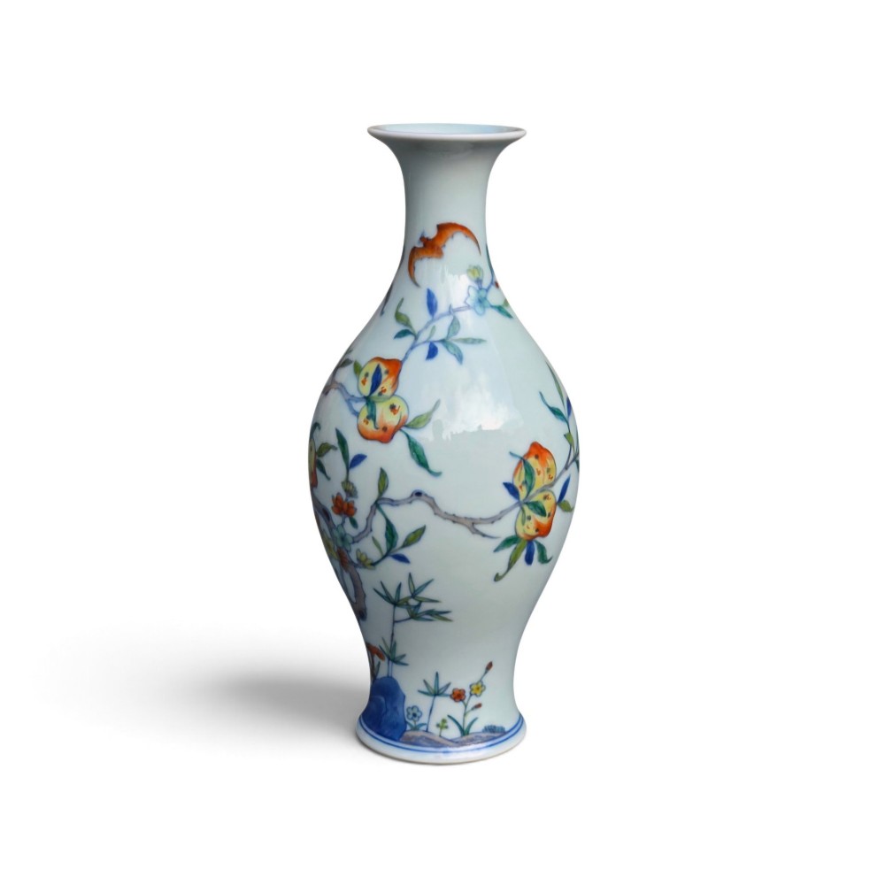 A Chinese porcelain garlic-head vase decorated with hand-painted peaches, orange bats, green leaves, and blue rockwork on a white background. View VII