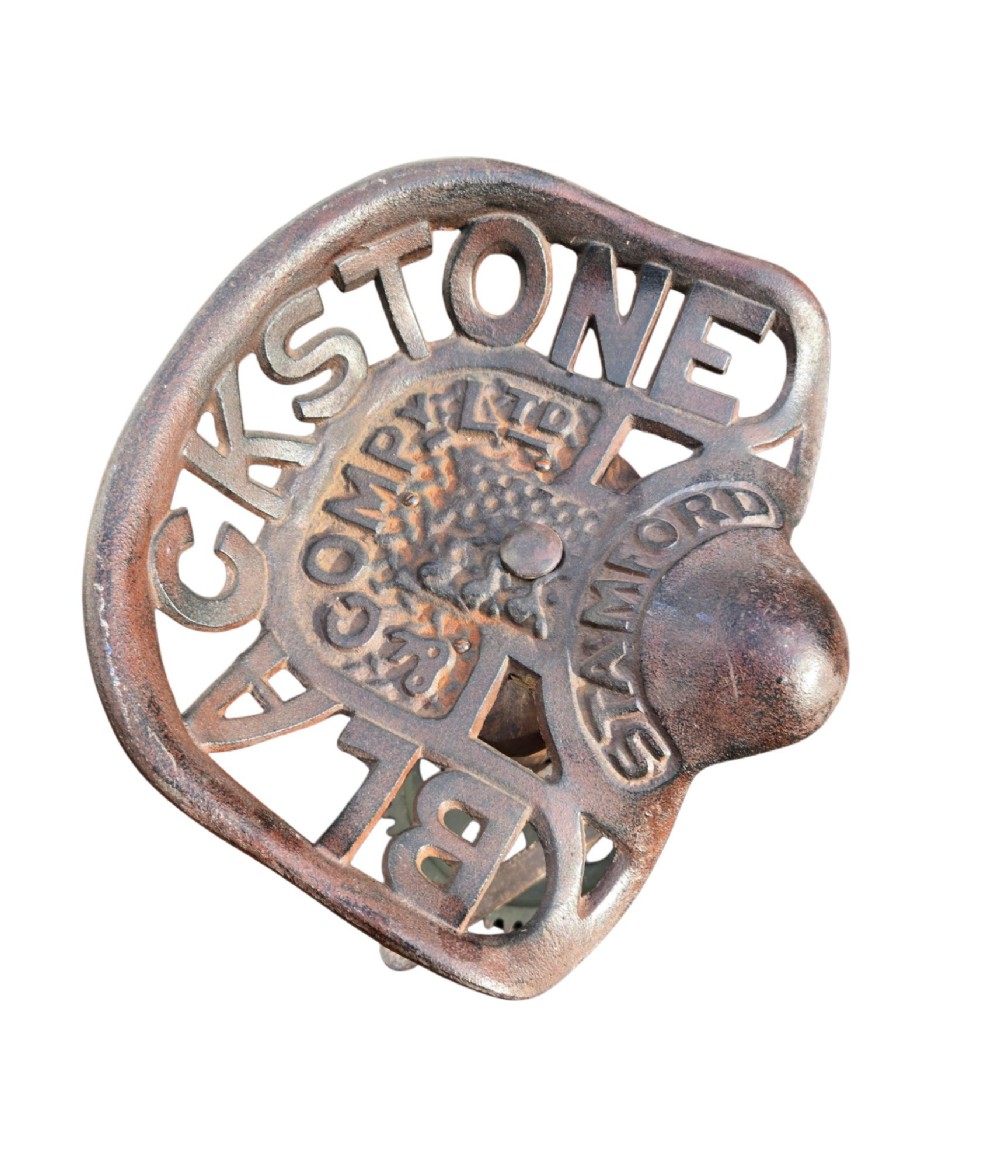 A pair of heavy industrial bar stools constructed with embossed Blackstone and Company cast-iron tractor seats, central metal columns with integrated footrests, and heavy gear cog bases. View X