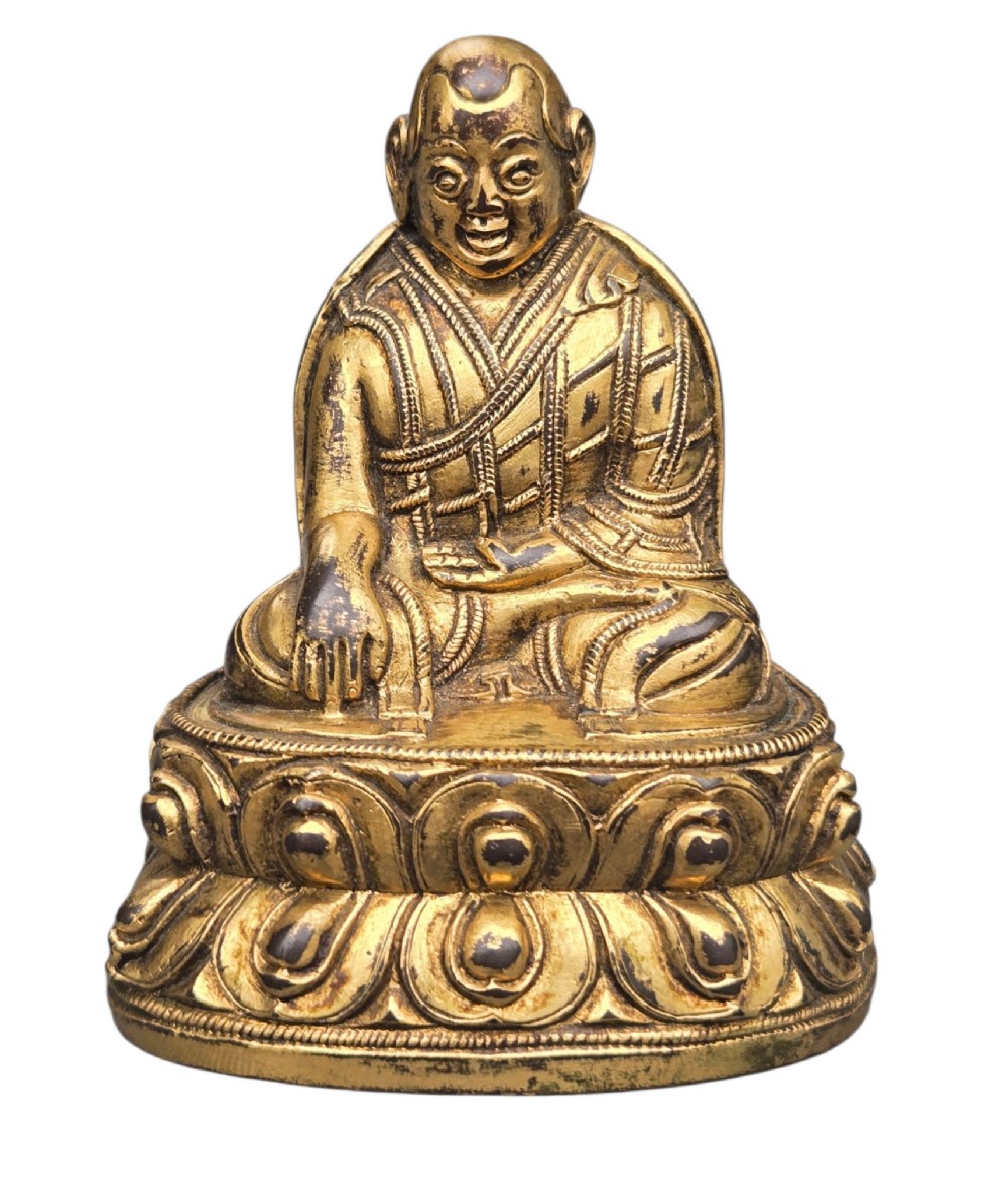 An 18th-century gilt-bronze miniature figure of Lama Shang seated cross-legged on a double-lotus pedestal in patterned robes. View II