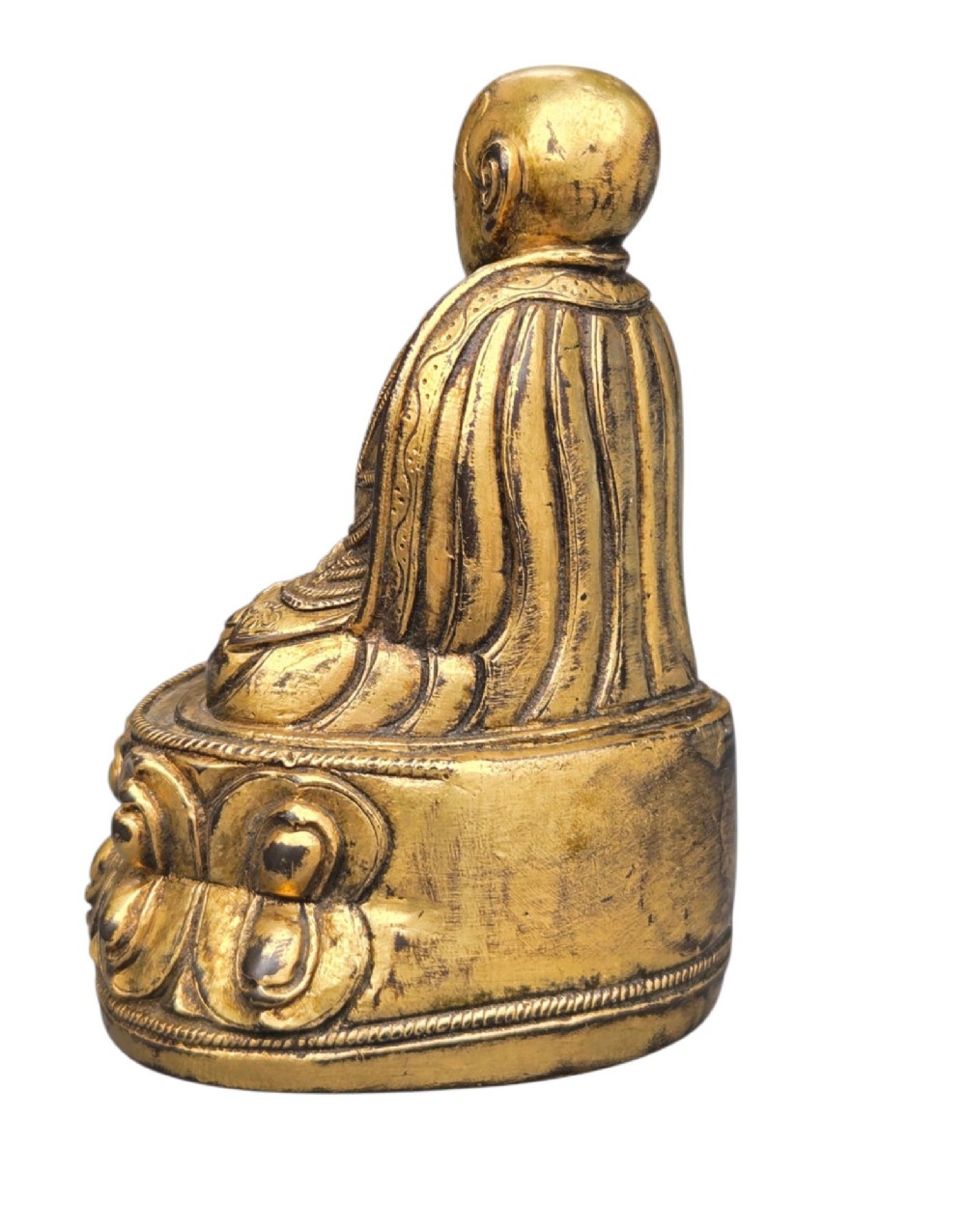 An 18th-century gilt-bronze miniature figure of Lama Shang seated cross-legged on a double-lotus pedestal in patterned robes. View V
