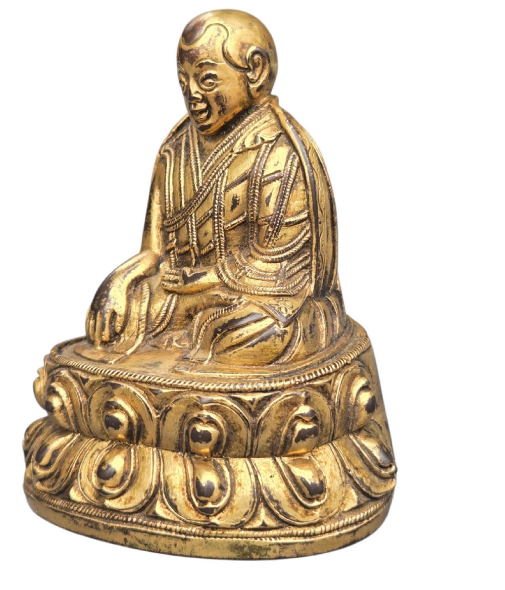 An 18th-century gilt-bronze miniature figure of Lama Shang seated cross-legged on a double-lotus pedestal in patterned robes. View VI