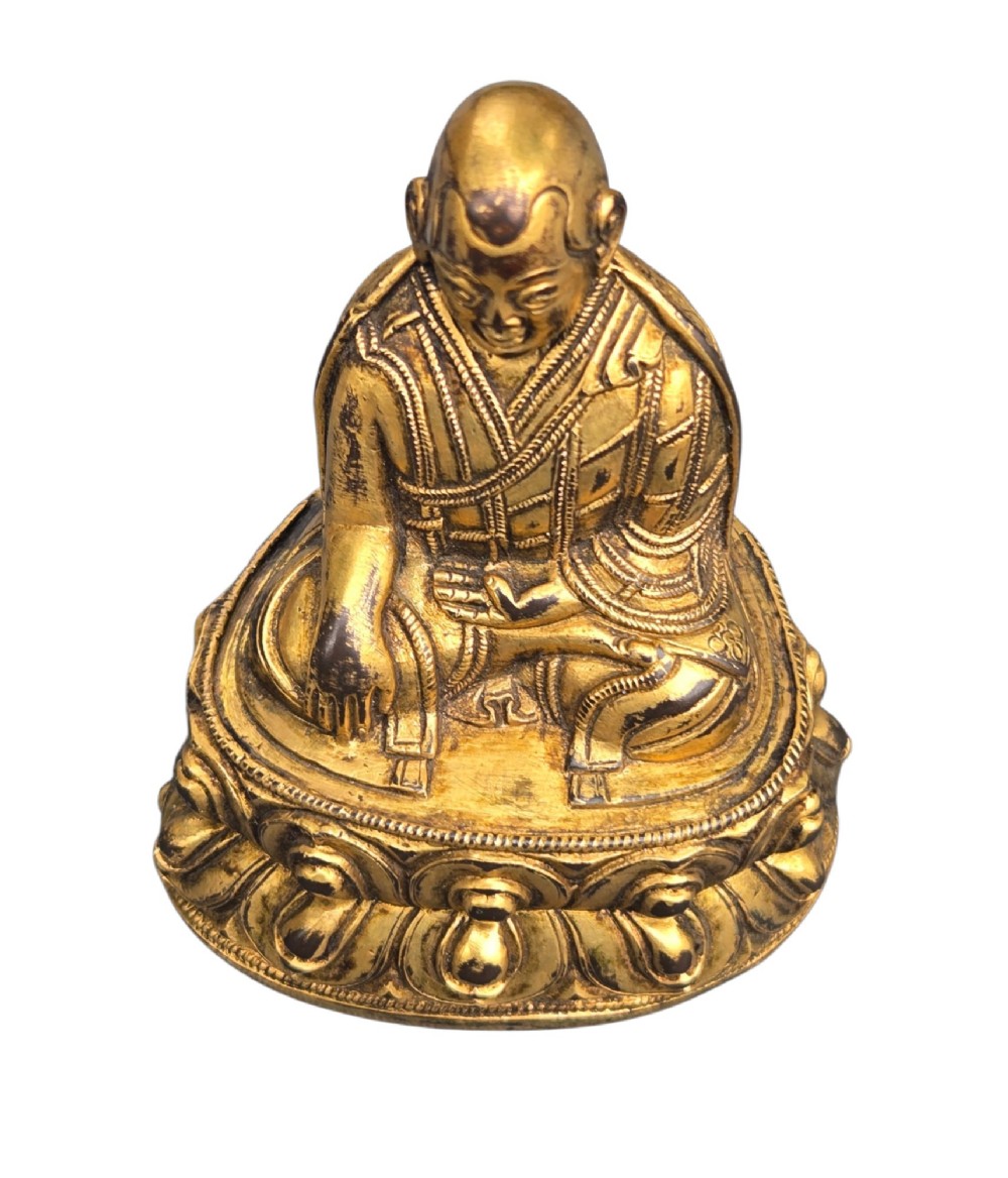 An 18th-century gilt-bronze miniature figure of Lama Shang seated cross-legged on a double-lotus pedestal in patterned robes. View VII