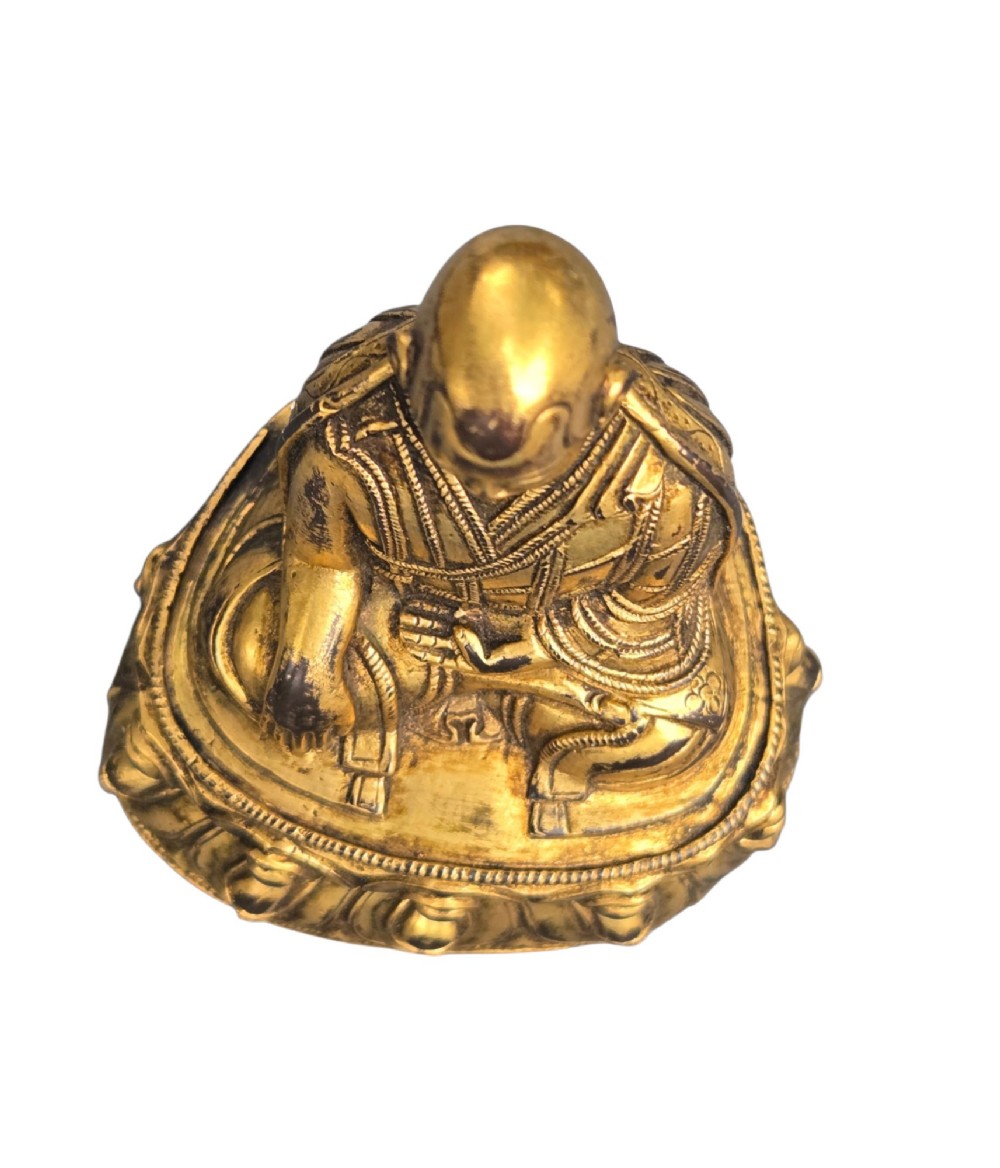 An 18th-century gilt-bronze miniature figure of Lama Shang seated cross-legged on a double-lotus pedestal in patterned robes. View VIII