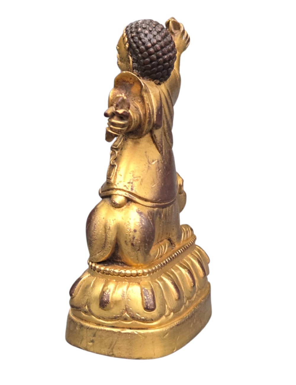 A sixteenth to seventeenth-century Sino-Tibetan gilt-bronze votive figure depicting a wrathful deity seated on a tiger atop a lotus pedestal. View V