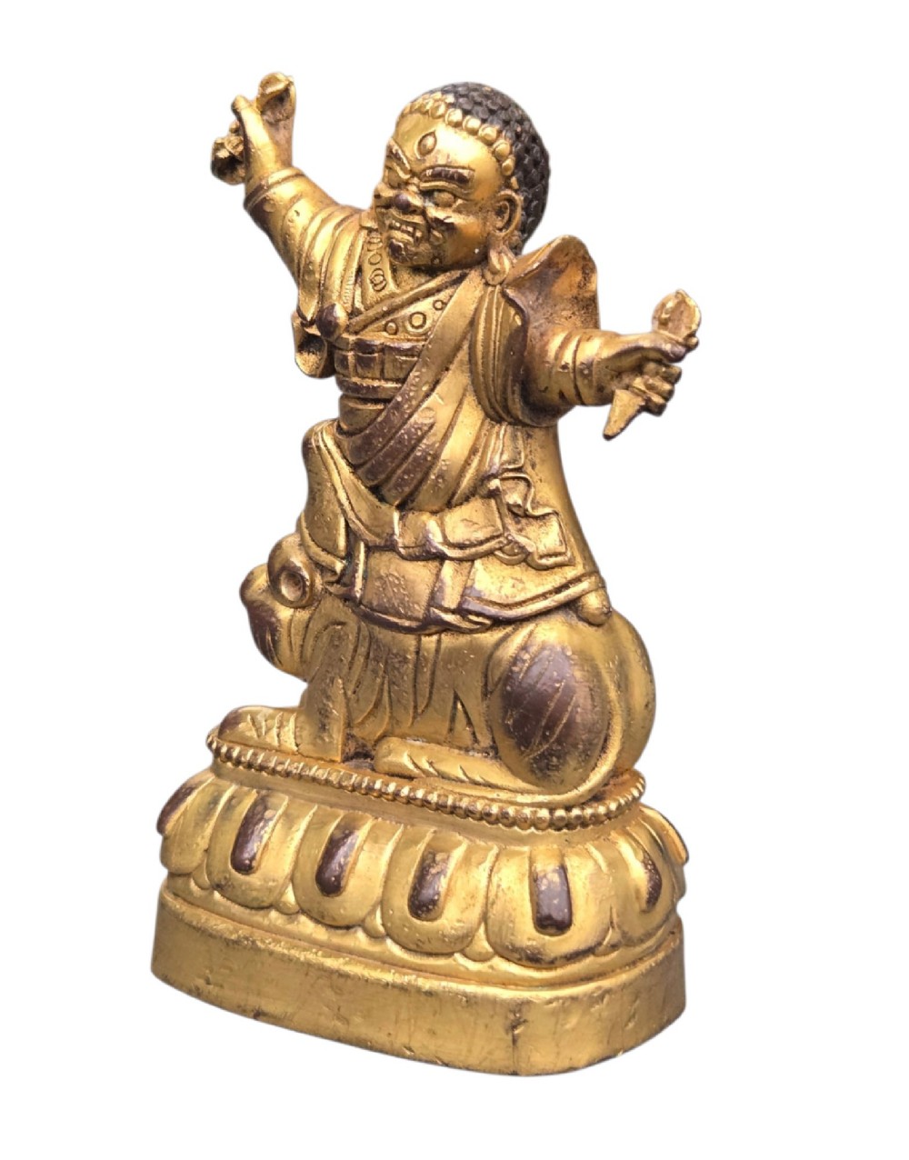 A sixteenth to seventeenth-century Sino-Tibetan gilt-bronze votive figure depicting a wrathful deity seated on a tiger atop a lotus pedestal. View VI