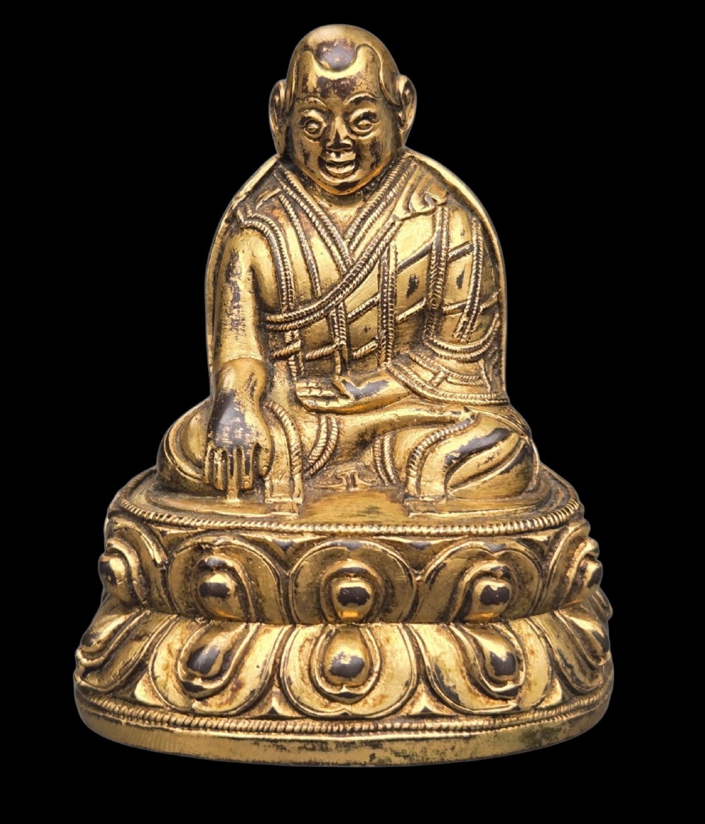 An 18th-century gilt-bronze miniature figure of Lama Shang seated cross-legged on a double-lotus pedestal in patterned robes. View XIII