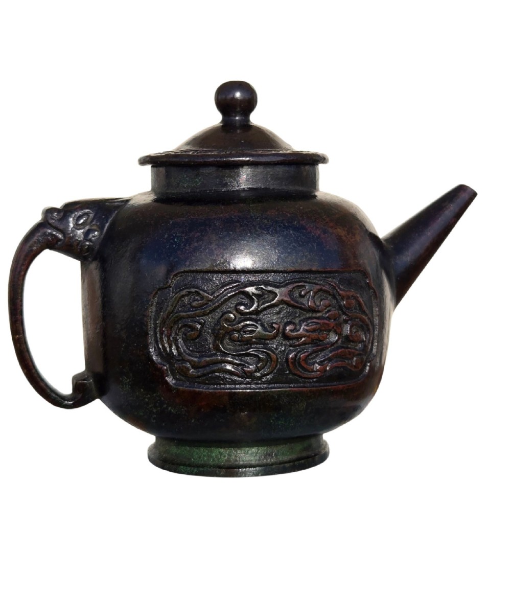 A dark patinated cast bronze vessel in ewer form featuring a dragon-head handle, a tapered spout, and carved relief panels. View XV