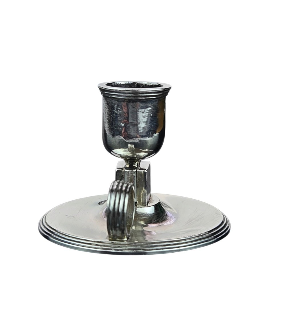 A small George III sterling silver taperstick featuring a flared sconce, a square central collar, a side ring handle, and a moulded circular base. View VII