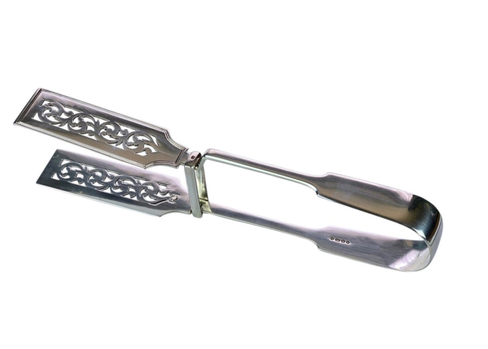 Victorian sterling silver asparagus tongs featuring wide, pierced scrollwork blades and clear assay hallmarks along the upper arm. View VII